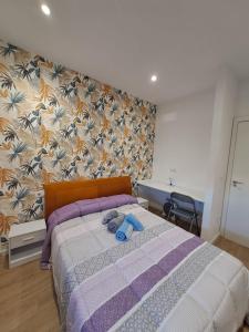 a bedroom with a bed with blue stuffed animals on it at 1º IZQ H-1 vistas al mar in Vigo