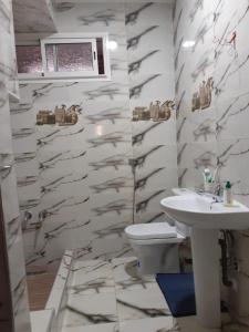 a white bathroom with a sink and a toilet at Chambre au centre de Rabat in Rabat