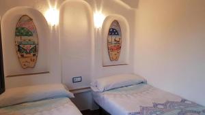two beds in a room with surfboards on the wall at Acacies 25 in Torroella de Montgrí +23 photos