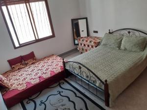 a bedroom with a bed and a couch and a window at Chambre au centre de Rabat in Rabat