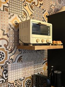 a microwave sitting on a shelf in a kitchen at Serenity Stone en las Sierras in Benaoján +36 photos