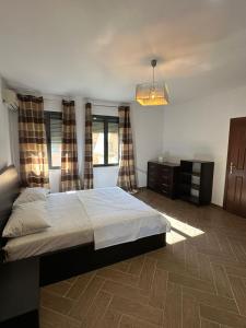 una camera con letto, cassettiera e finestre di Hana Apartments TIRANA a Tirana Altre 108 foto