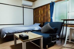 a bedroom with a bed and a chair and a table at Atami Ajiro no kaze - Vacation STAY 40583v in Atami