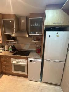 a kitchen with a refrigerator and a stove at Nasay Magic World in El Borseral