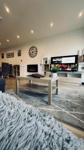 a living room with a table and a clock on the wall at 5 chapel row in Wirksworth
