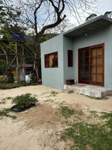 a small white house with a window in a yard at Chalé Água viva in Paraty