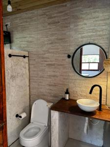 a bathroom with a sink and a toilet and a mirror at Chalé Água viva in Paraty +15 photos