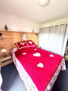 ein Schlafzimmer mit einer roten Tagesdecke mit Herz darauf in der Unterkunft Nid douillet au pied des pistes in Les Angles