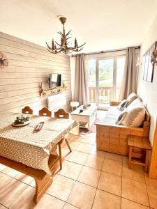 ein Wohnzimmer mit einem Bett und einem Tisch in der Unterkunft Nid douillet au pied des pistes in Les Angles