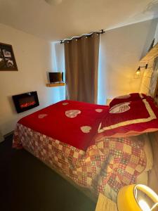 Schlafzimmer mit einem Bett mit einer roten Bettdecke in der Unterkunft Nid douillet au pied des pistes in Les Angles + 4 Fotos