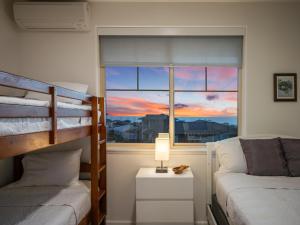 una camera da letto con un letto a castello e una finestra di Kalo Homes - Mauka to Makai a Makaha Valley Altre 87 foto