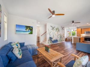 a living room with a blue couch and a table at Kalo Homes - Immersed in Aloha in Makaha Valley