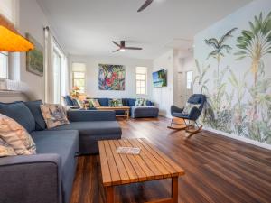 a living room with a blue couch and a table at Kalo Homes - Immersed in Aloha in Makaha Valley