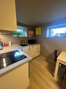 cocina con armarios blancos, mesa y ventana en Modern basement apartment, en Stavanger 17 fotos más