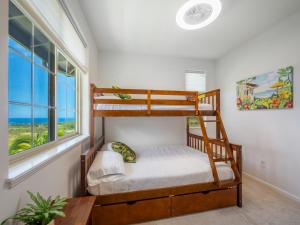 a bedroom with two bunk beds and a window at Kalo Homes - Immersed in Aloha in Makaha Valley +84 photos