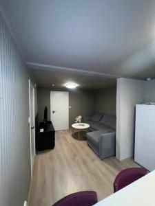 una sala de estar con un sofá y una mesa en Modern basement apartment, en Stavanger