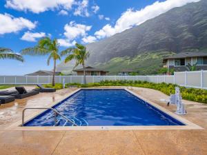 a swimming pool with a mountain in the background at Kalo Homes - Immersed in Aloha in Makaha Valley