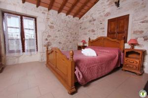 a bedroom with a bed with a white cat laying on it at La Ferme Des Rosières - Chambres in La Garde-Adhémar +13 photos
