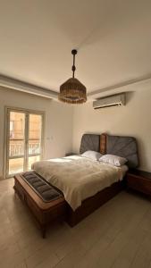 a bedroom with a large bed with a chandelier at Modern apartment near AUC - 3BR in Cairo