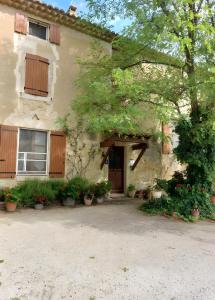 a house with plants and flowers in front of it at La Ferme Des Rosières - Chambres in La Garde-Adhémar