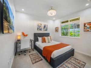 a bedroom with a bed and a desk and a window at Kalo Homes - Elevated Escape in Makaha Valley +78 photos