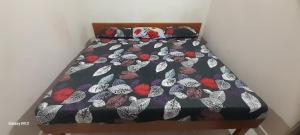 a bed with a comforter with butterflies on it at Mahadev Residency in Tiruvannāmalai