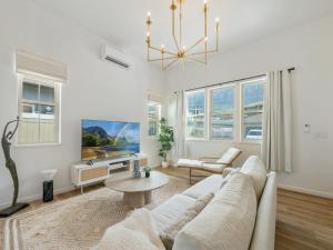 un salon avec un canapé blanc et une télévision dans l'établissement Kalo Homes - The Vista Villa, à Makaha Valley