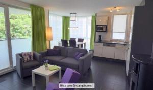 a living room with a couch and a kitchen at Strandpark-Grossenbrode-Haus-Meeresrauschen-Wohnung-11 in Großenbrode-Kai