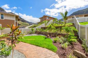 a yard with grass and plants in a house at Kalo Homes Tropical Palm Getaway in Makaha Valley