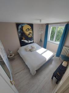 a bedroom with a bed with a painting on the wall at Ker Raphaël in Guérande