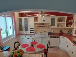 a kitchen with white cabinets and a table with fruits on it at Ker Raphaël in Guérande +31 photos