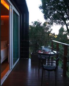 a patio with a table and chairs on a porch at HOSPEDE-SE EM UM CONTAINER AO LADO DE GRAMADO - RS in Igrejinha