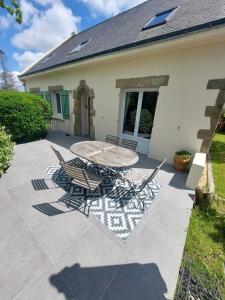 a patio with a table and chairs in front of a house at Ker Raphaël in Guérande
