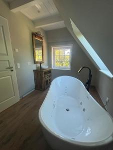 a large white bath tub in a bathroom with an attic at Nebel-s-Hues-Og in Nebel +14 photos