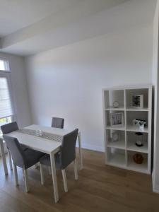 a dining room with a table and chairs and a book shelf at Modern Stylish Cozy Home Balcony Wifi in Caledonia +5 photos