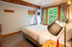 una camera da letto con un letto e una finestra di South Swell Tofino (formerly Blue Heron Waterfront Home amid Old Growth Cedars) a Tofino