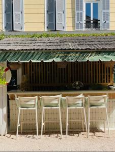 a group of chairs sitting in front of a bar at Hôtel De Londres in Menton
