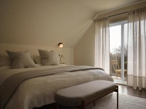 a bedroom with a large bed and a large window at Pinôt Boutique Hôtel in Sutton
