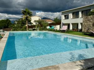 a blue swimming pool in front of a house at Domaine LUMISTELLA 2 in Porticcio