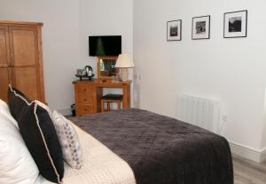 a bedroom with a bed and a desk with a television at Gwesty Seren Hotel in Blaenau-Ffestiniog