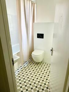 a bathroom with a toilet and a black and white tile floor at Studio flat in central London in London