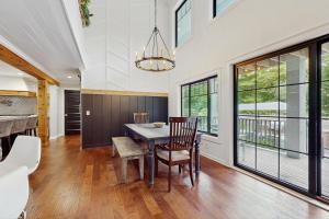 a dining room with a table and chairs and windows at Serenity Woods Family Retreat in Glen Lord