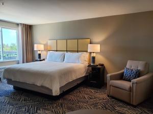 a hotel room with a bed and a chair at Candlewood Suites - Lake Charles South by IHG in Lake Charles