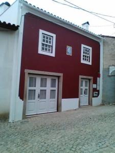 un edificio rosso e bianco con due porte bianche di Casa Rural Santa Teresinha a Campo de Víboras