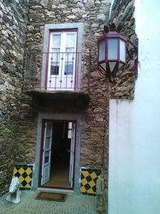 un gatto seduto di fronte a un edificio con una finestra di Casa Rural Santa Teresinha a Campo de Víboras