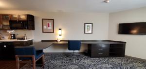 an office with a desk and two blue chairs at Candlewood Suites - Lake Charles South by IHG in Lake Charles +20 photos