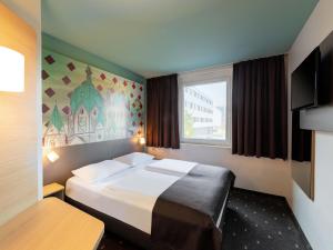 a hotel room with a bed and a window at B&B Hotel Neuss in Neuss