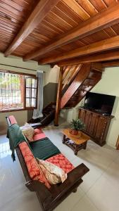 un soggiorno con divano e TV a schermo piatto di Ñande Roga Apart a Puerto Iguazú