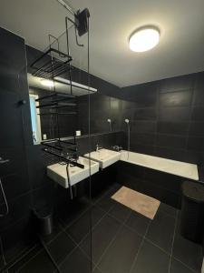 a bathroom with two sinks and a tub and a mirror at Skau Sky Park Mint by Zaha Hadid 22 Floor 1 Tower Free Parking in Staré Mesto