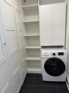 a washer and dryer in a white closet at Skau Sky Park Mint by Zaha Hadid 22 Floor 1 Tower Free Parking in Staré Mesto +11 photos